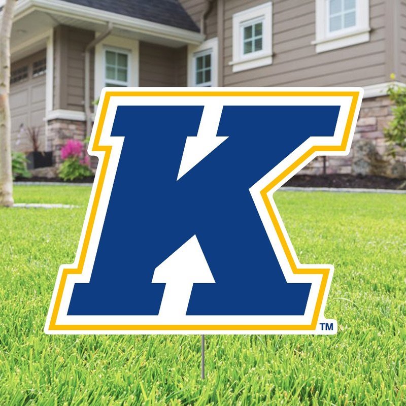 Kent State K Logo Lawn Sign featuring a bold blue and gold K emblem displayed on a green lawn in front of a suburban house, representing Kent State University pride.