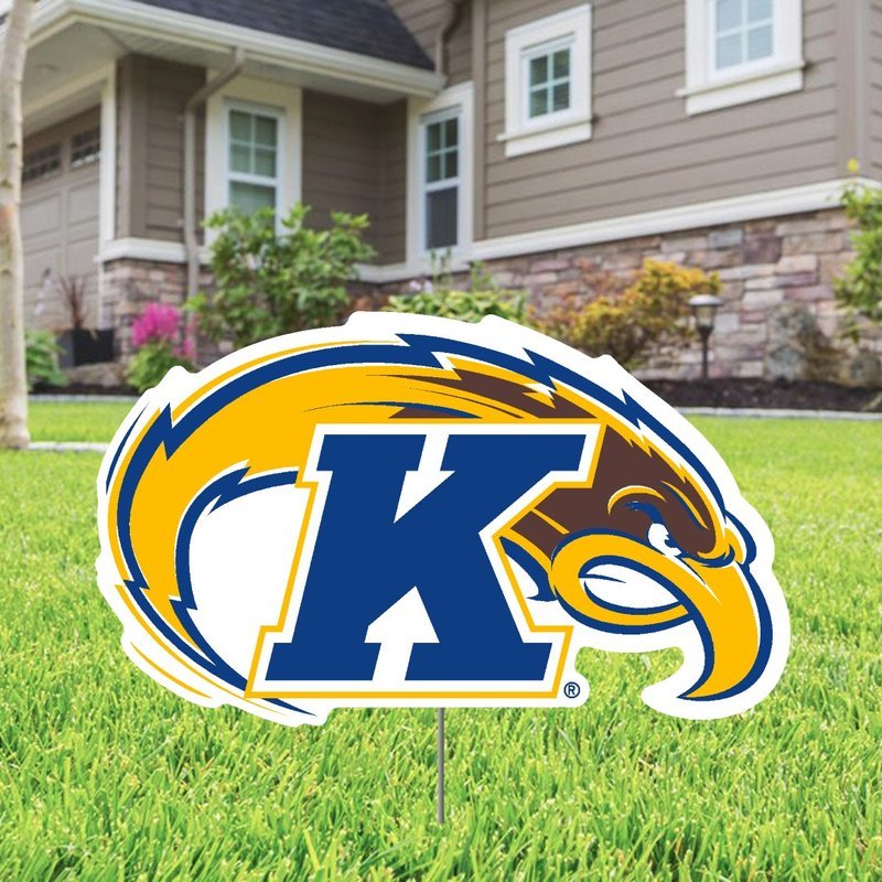 Kent State Primary Logo Lawn Sign featuring a large blue K with a golden eagle head and wing design, displayed on green grass in front of a suburban house.